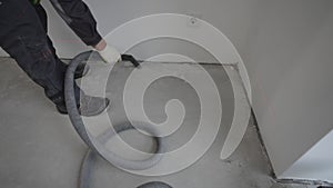 Builders clean the floor with an industrial vacuum cleaner before applying the epoxy primer. Self-levelling epoxy floor