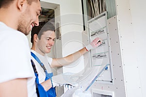 Builders with clipboard and electrical panel