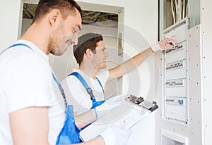 Builders with clipboard and electrical panel