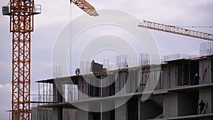 Builders on the edge of a skyscraper under construction. Workers at a construction site.