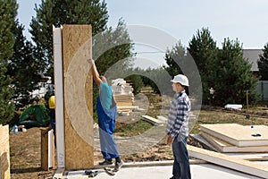 Builders erecting insulated wall panels