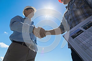 Builders Handshake, Architect And Contractor Agreement During Meeting Discussing Blueprint Buiding Plan On Construction