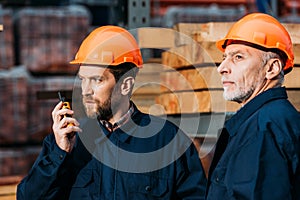 builders in hardhats working with walkie talkie outside