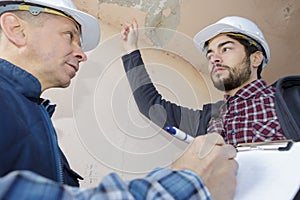 Builders inspecting roof damage