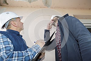 builders inspecting roof damage