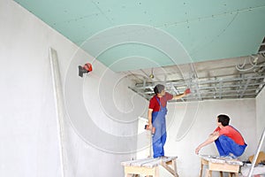 The builders install the ceiling profile in the photo