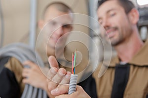 Builders looking at cables coming out grey trunking