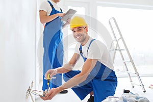 Builders with tablet pc and equipment indoors