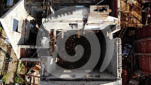 Builders walk past abandoned cottage at demolition site