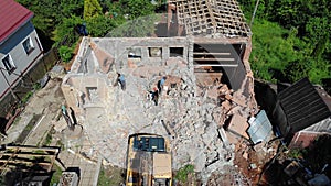 Builders walk about rubbles of cottage at demolition site