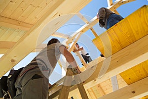 Builders at work with wooden roof construction.