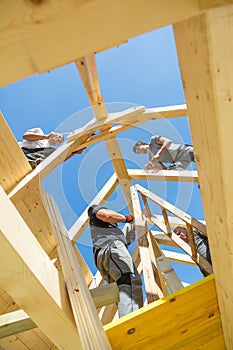 Builders at work with wooden roof construction.