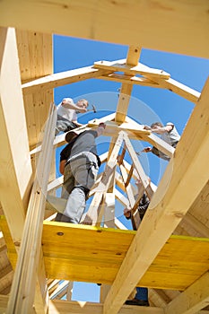 Builders at work with wooden roof construction.