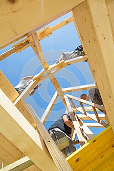 Builders at work with wooden roof construction.