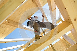 Builders at work with wooden roof construction.