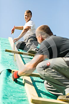 Builders at work with wooden roof construction.