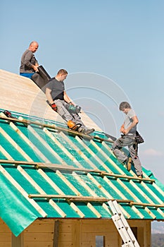 Builders at work with wooden roof construction.