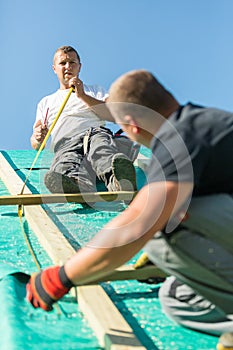 Builders at work with wooden roof construction.