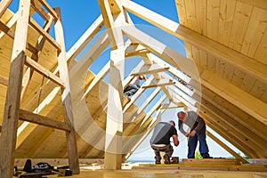 Builders at work with wooden roof construction.