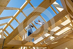 Builders at work with wooden roof construction.