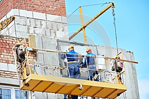 Builders worker installing glass windows on facade