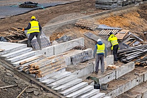 Builders working on construction foundation. Man strengthen concrete structure on the hill slope