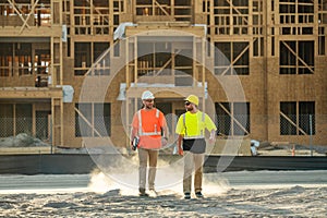 Builders working. Two builders in a hard hat is busy working on a construction project at a site. A builders workes in a