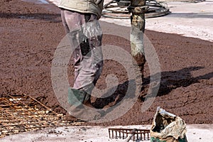 Builders works on the construction site: pouring brown concrete for foundation