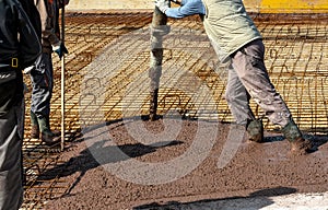 Builders works on the construction site: pouring brown concrete for foundation