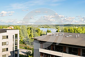 Building with apartments, condos in residential area. Park, green forest and lake landscape view. Outside facade of house.