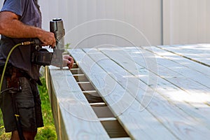 Building a backyard deck with worker putting with nail gun patio construction terrace