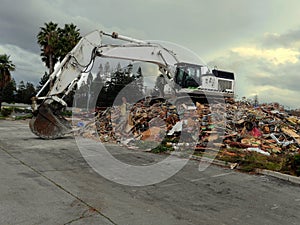 Building being demolished by a powerful excavator