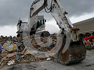 Building being demolished by a powerful excavator