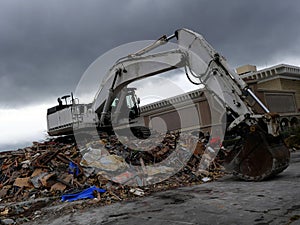 Building being demolished by a powerful excavator