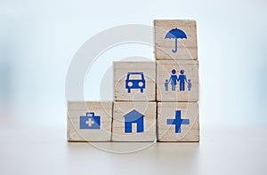 Building blocks of medical, house and life insurance cover on blurred background for family, safety and healthcare icon