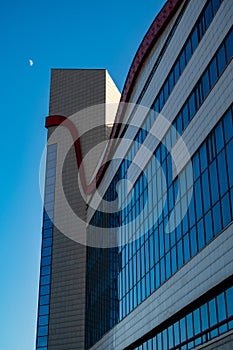 building with blue glass and stained-glass windows against the background of a blue evening sky with the moon