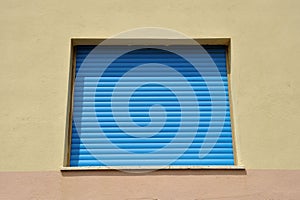 a building with a blue roller door and the windows closed