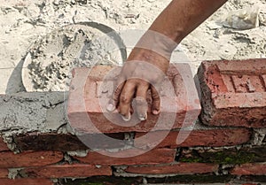 Building brick block wall on construction plant.Worker builds a brick wall in the house.Construction worker laying bricks on ext