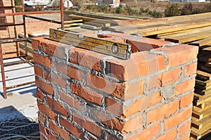 Building brick chimney in unfinished house construction roof. Bricklaying chimney.