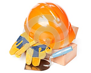 Building bricks, hard hat, trowel and gloves
