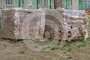 Building bricks in torn plastic packaging stand on the lawn