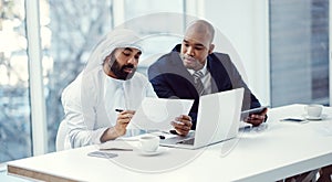 Building a business by bringing the best to the table. two businessmen using a digital tablet and laptop while having a