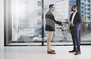 Building a business together. two businessmen shaking hands at work.
