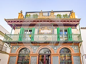 building with ceramic tiles on the facade and wrought iron balconies in the center of the old town of Triana