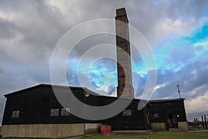 Building with a chimney against the cloudy sky. Auschwitz concentration camp, Poland.