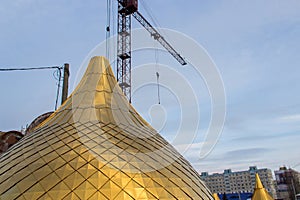 Building a church, consruction site. Golden dome of the Orthodox church in Central Russia on the blue sky background. Close up sho