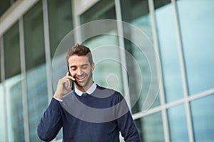 Building connections with my clients. a handsome young businessman standing alone outside and using his cellphone during