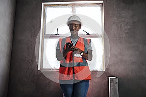 Building connections one brick at a time. a young woman using a smartphone while working at a construction site.