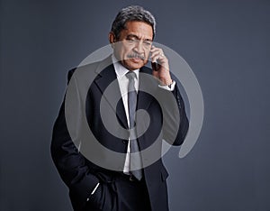 Building connections. Studio shot of a mature businessman talking on his cellphone.