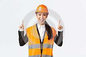 Building, construction and industrial concept. Happy smiling female asian engineer in safety helmet and reflective